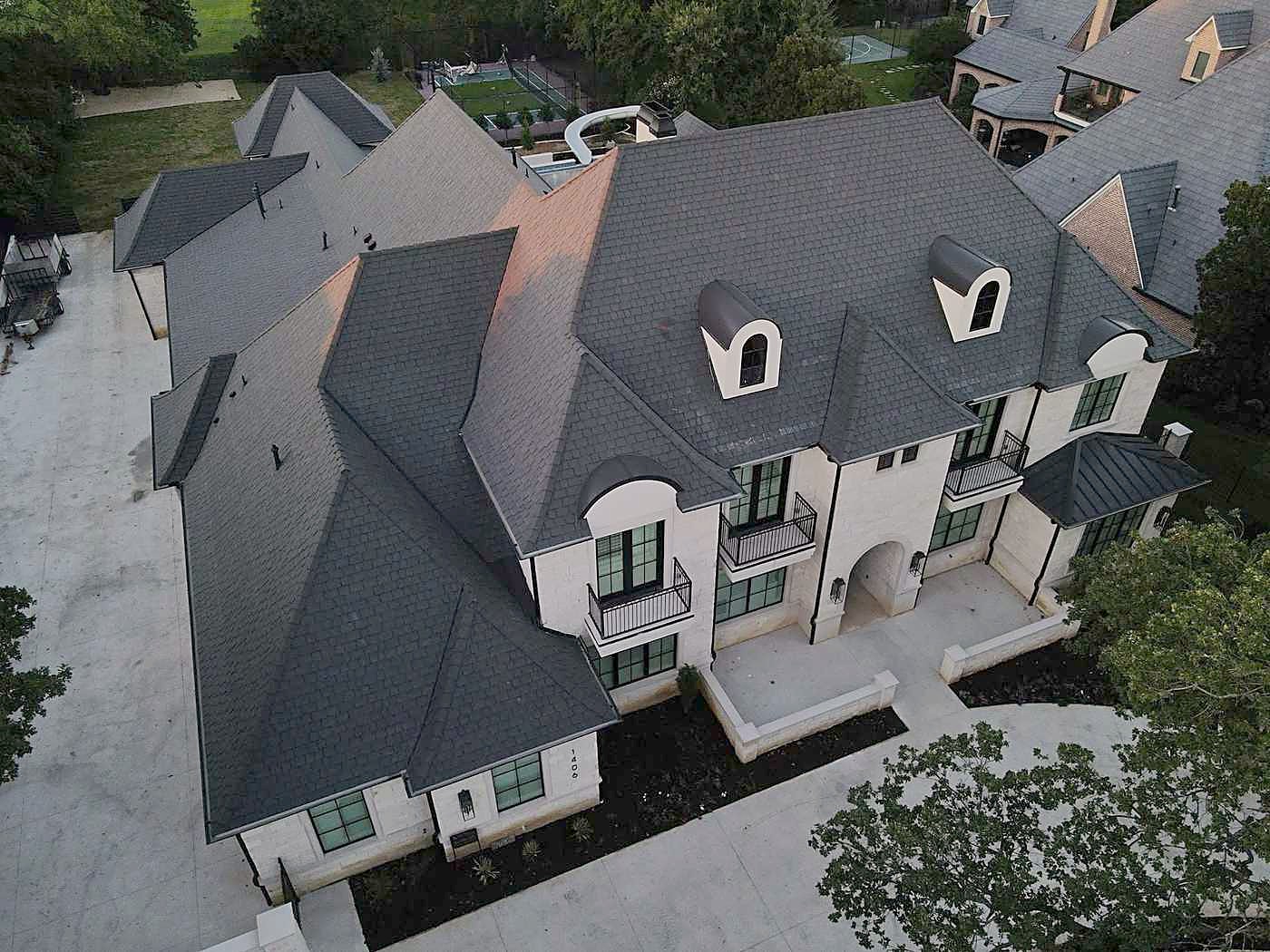 A new dark shingle roof on a white house, seen from above